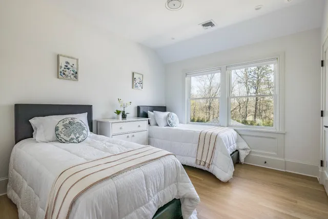 a bedroom with two beds and a window