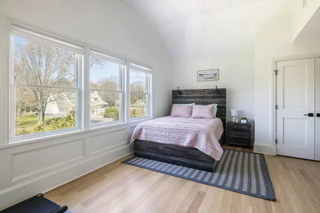 a bedroom with a bed and wooden floor