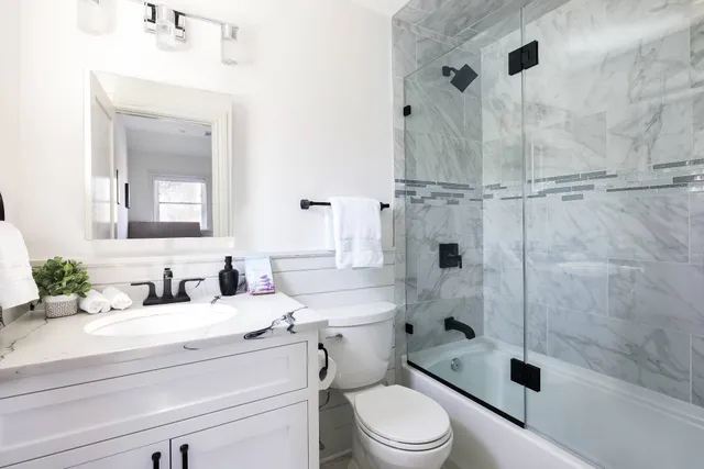 a bathroom with a sink a toilet and shower