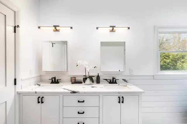 a bathroom with double sink and a mirror