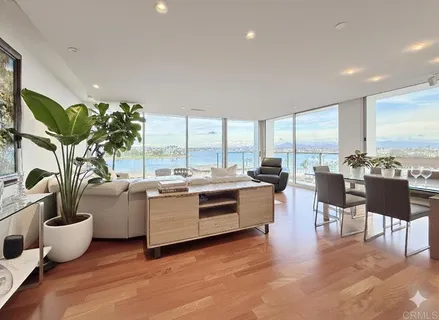 a living room with furniture kitchen view and large windows