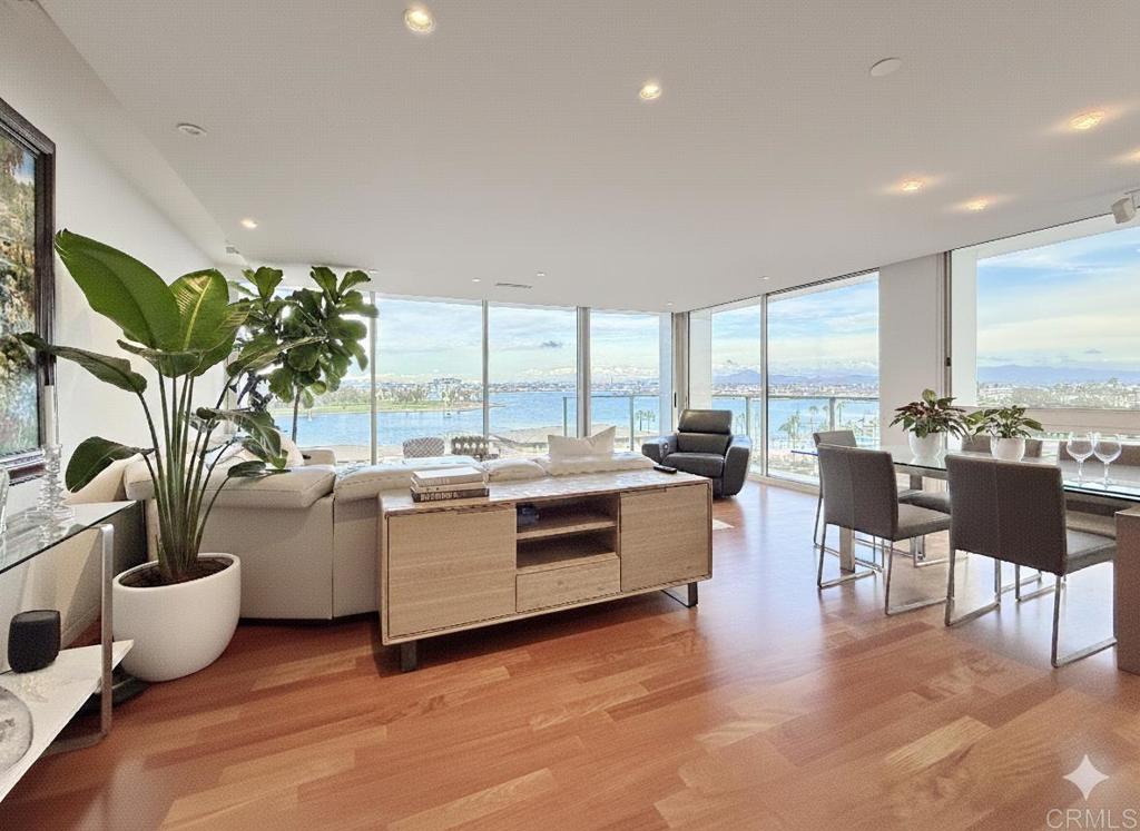 a living room with furniture kitchen view and large windows