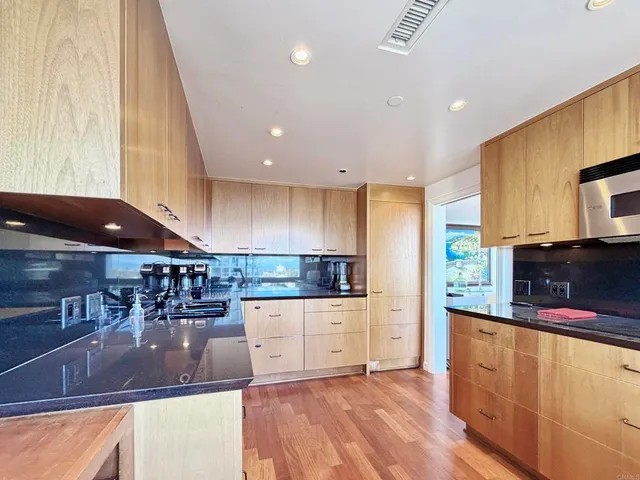 a kitchen with stainless steel appliances granite countertop a sink and a stove