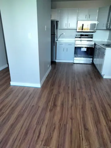 a kitchen with wooden floors and appliances