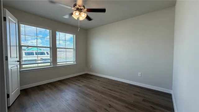 a view of room with window ceiling fan and hardwood floor