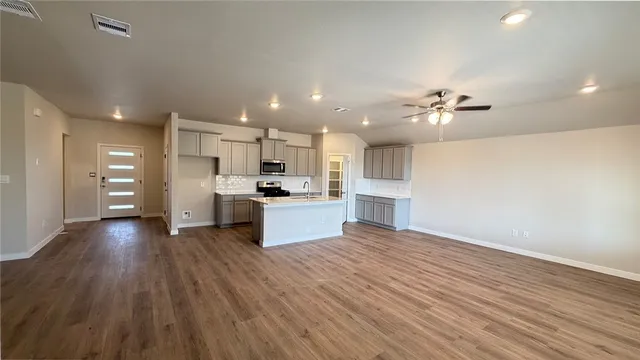 a view of kitchen with wooden floor electronic appliances and window