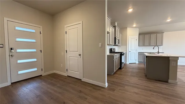 a large kitchen with a center island wooden floor stainless steel appliances and a window