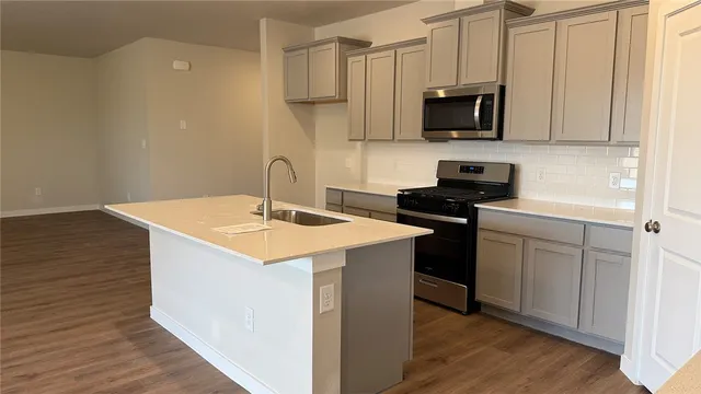 a kitchen with stainless steel appliances granite countertop a sink stove and cabinets