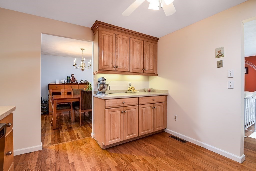 101 Standish Road Needham, MA 02492 - Photo 12 of 38 a kitchen with granite countertop wooden cabinets a dining table and chairs