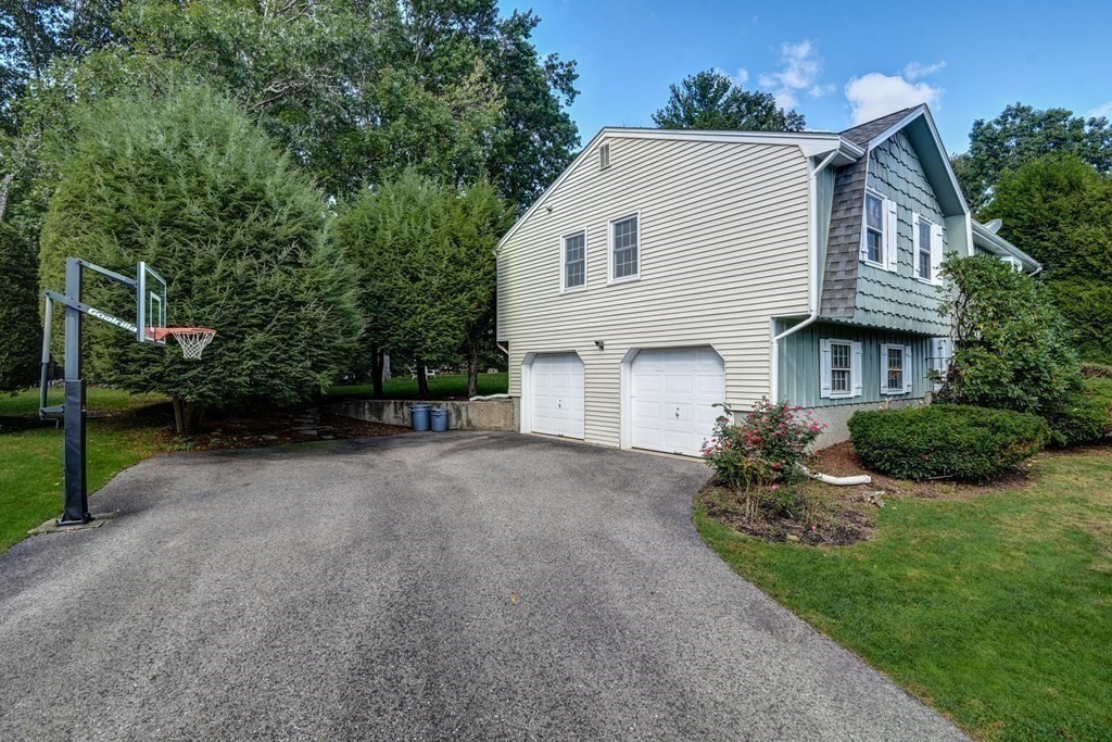 101 Standish Road Needham, MA 02492 - Photo 36 of 38 a view of a white house next to a yard and large trees