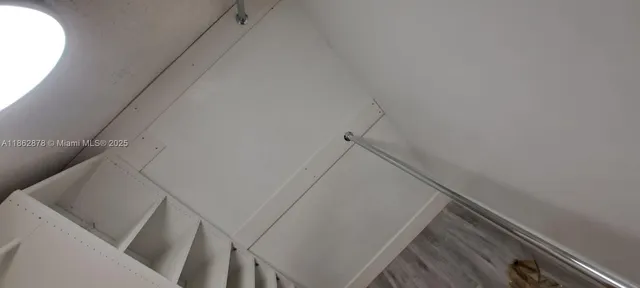 a view of hallway with stairs and wooden floor