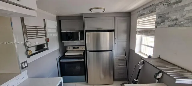 a kitchen with a refrigerator and a stove top oven