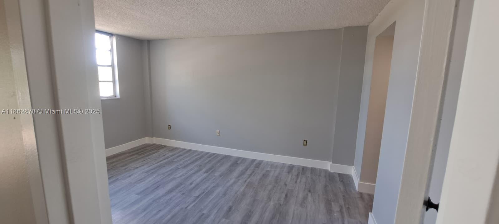 14180 Southwest 84th Street, Unit 203G Miami, FL 33183 - Photo 10 of 17 a view of an empty room with wooden floor