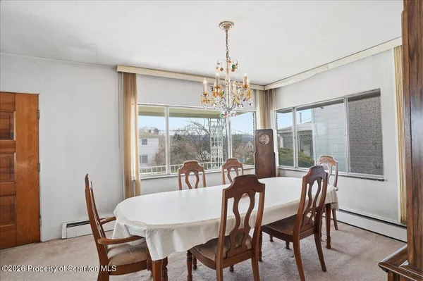 a living room with dining table and a large window