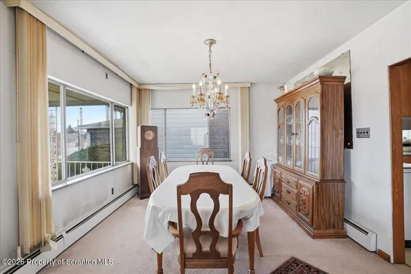 a view of a dining room with furniture and a chandelier