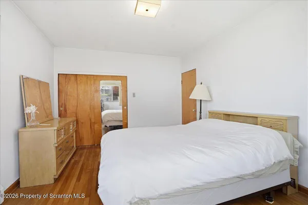 a bedroom with a bed and wooden floor