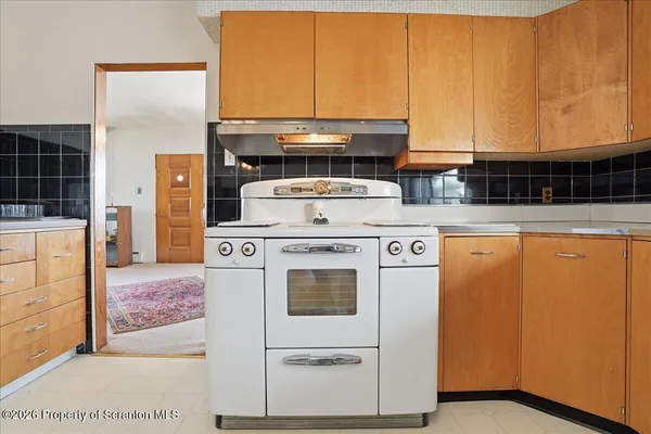 a stove top oven sitting inside of a kitchen