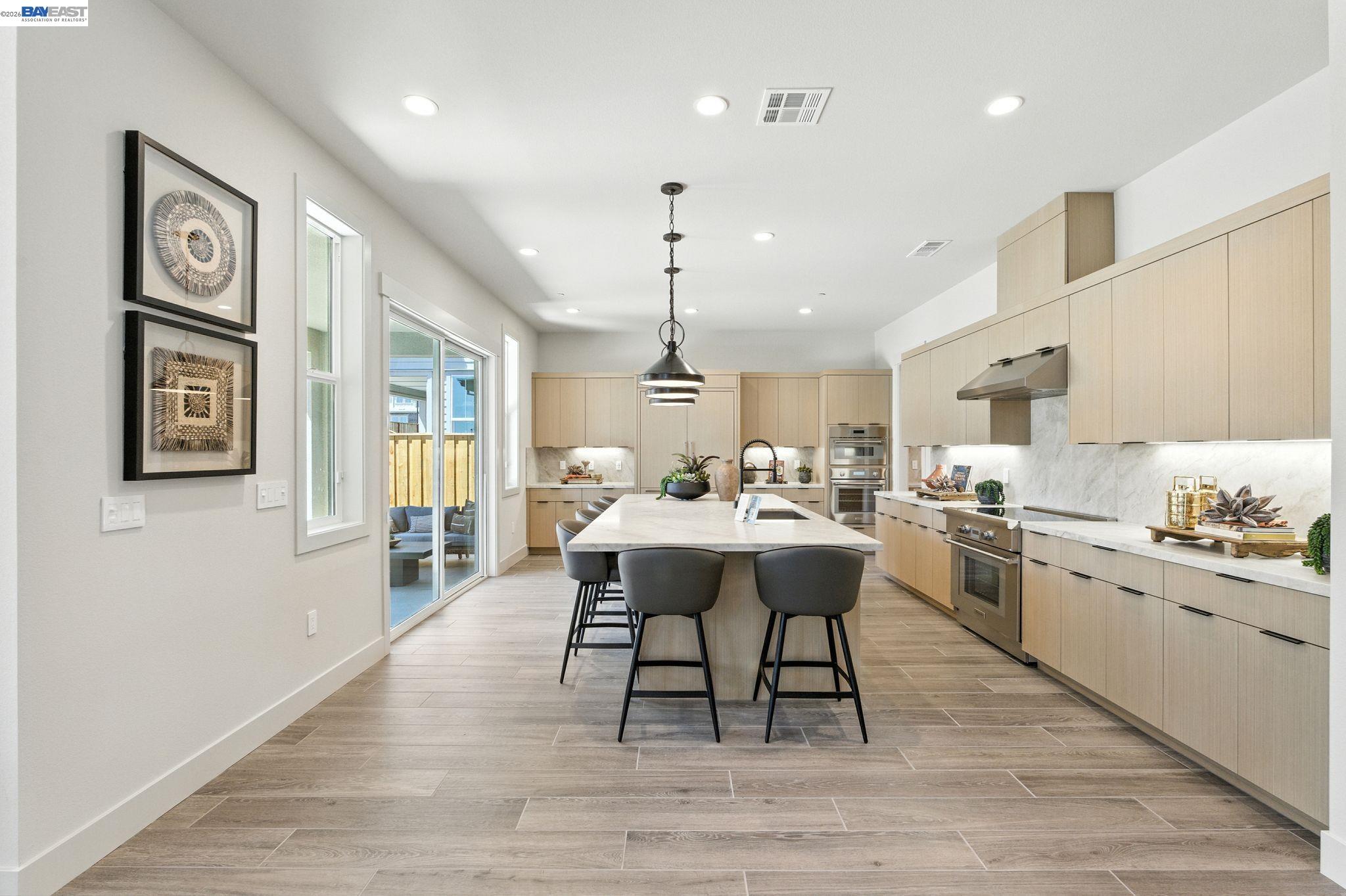 4237 Langley Road Dublin, CA 94568 - Photo 7 of 40 a kitchen with stainless steel appliances granite countertop a sink dishwasher and a dining table with wooden floor