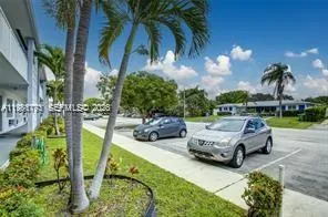 a car parked in front of yellow house with trees