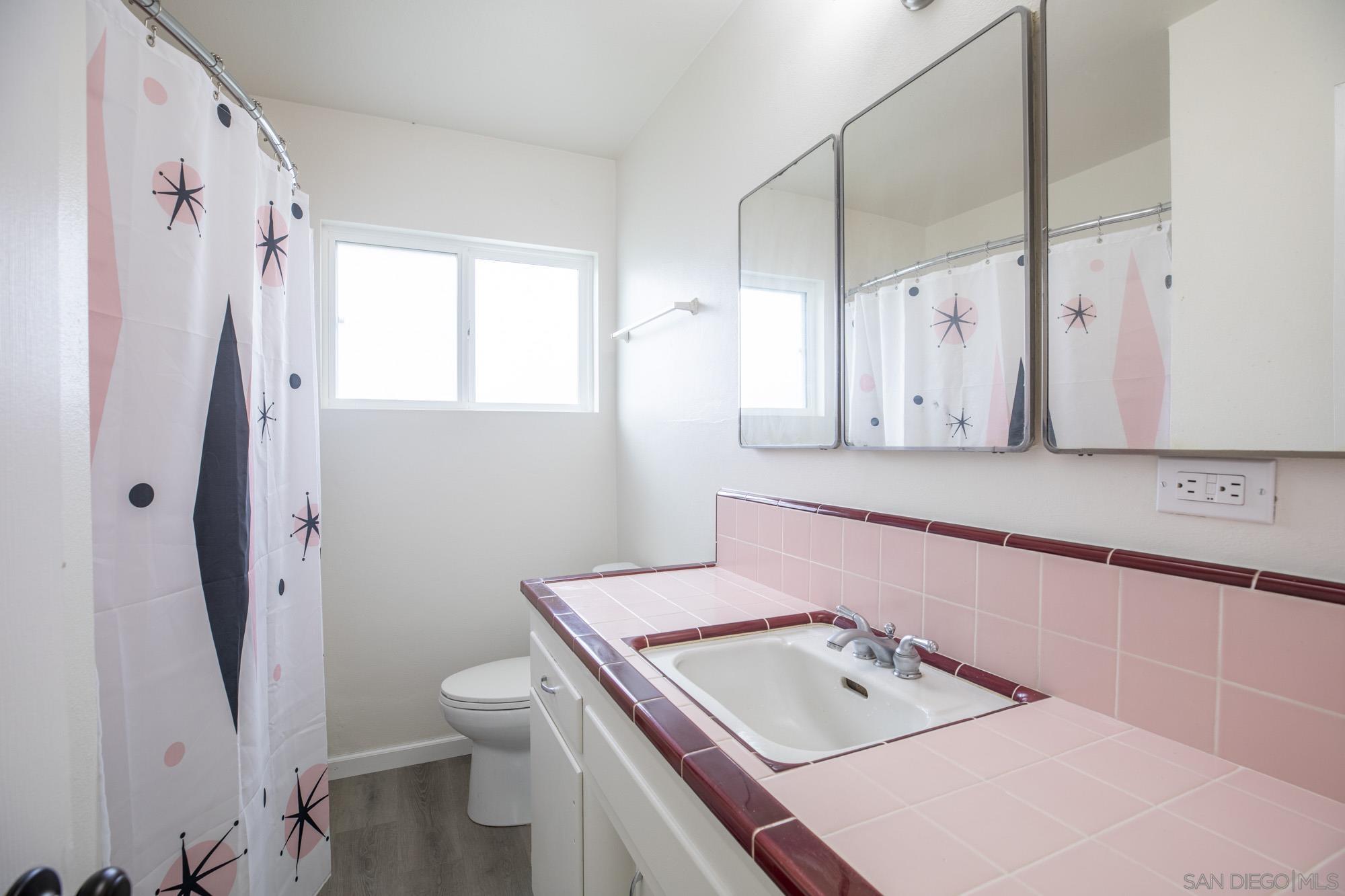 6979 Tower Street La Mesa, CA 91942 - Photo 16 of 30 a bathroom with a sink a toilet and a mirror