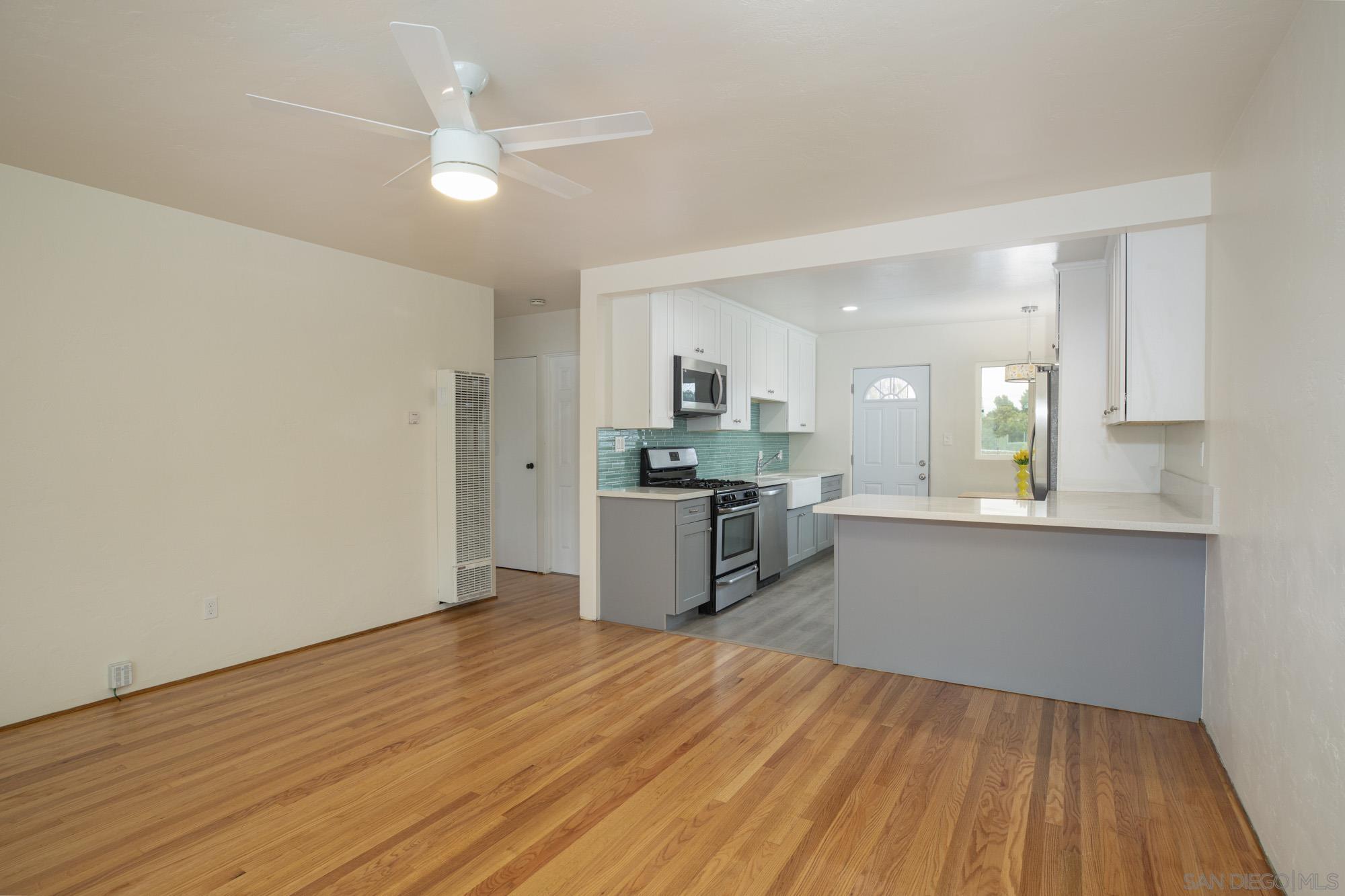 6979 Tower Street La Mesa, CA 91942 - Photo 5 of 30 a kitchen with stainless steel appliances granite countertop a sink cabinets and wooden floor