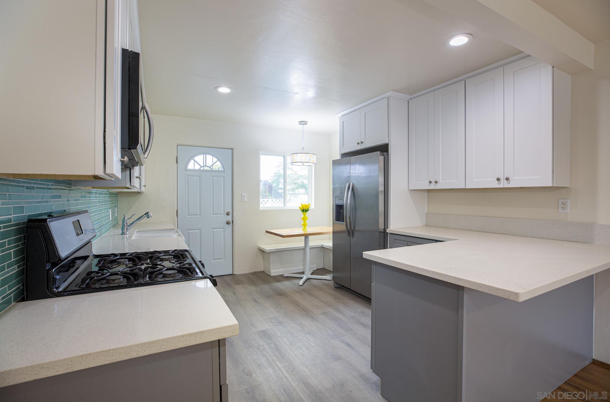 6979 Tower Street La Mesa, CA 91942 - Photo 6 of 30 a kitchen that has a sink and a stove in it