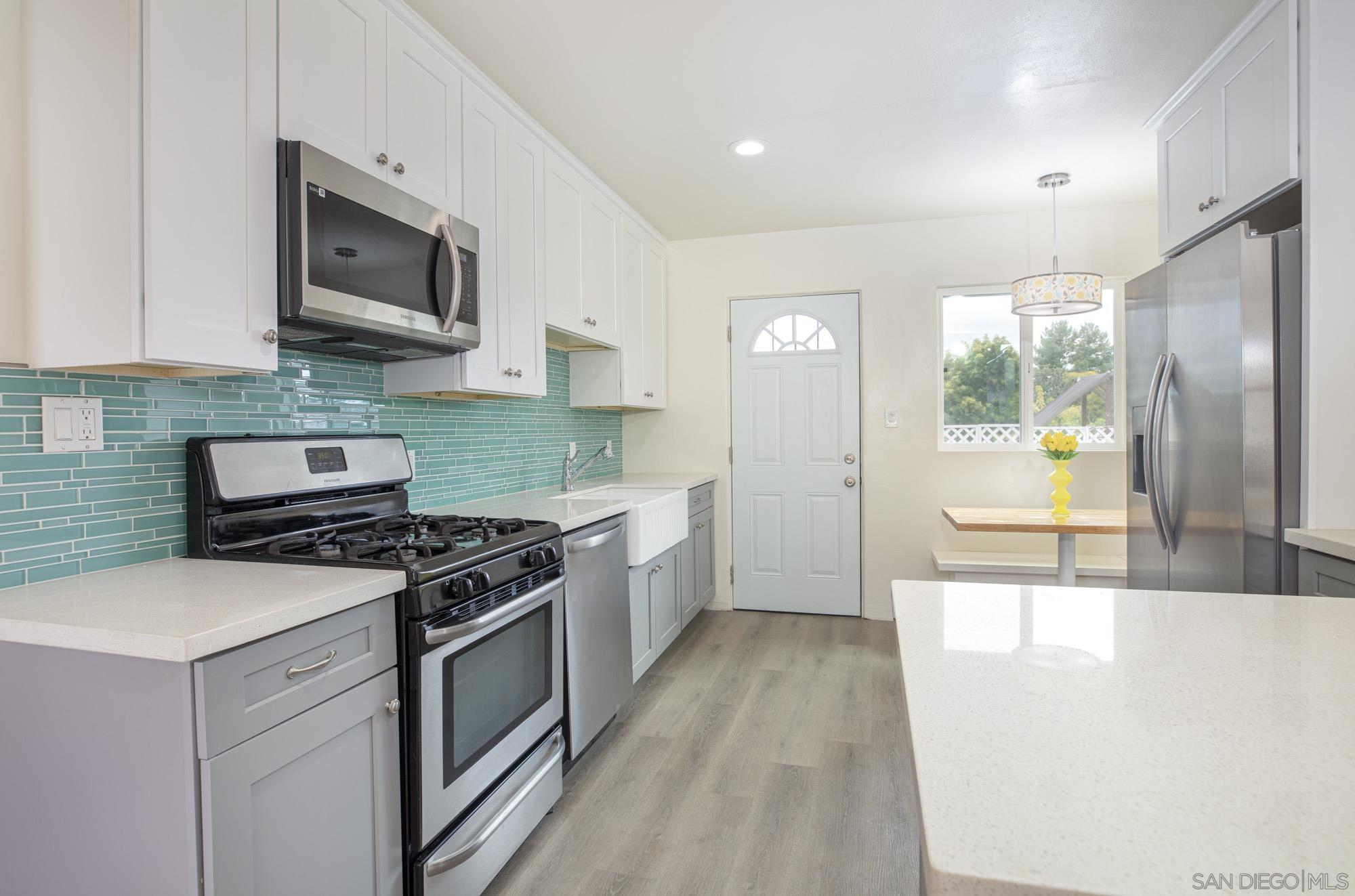6979 Tower Street La Mesa, CA 91942 - Photo 7 of 30 a kitchen with stainless steel appliances a stove sink microwave and cabinets