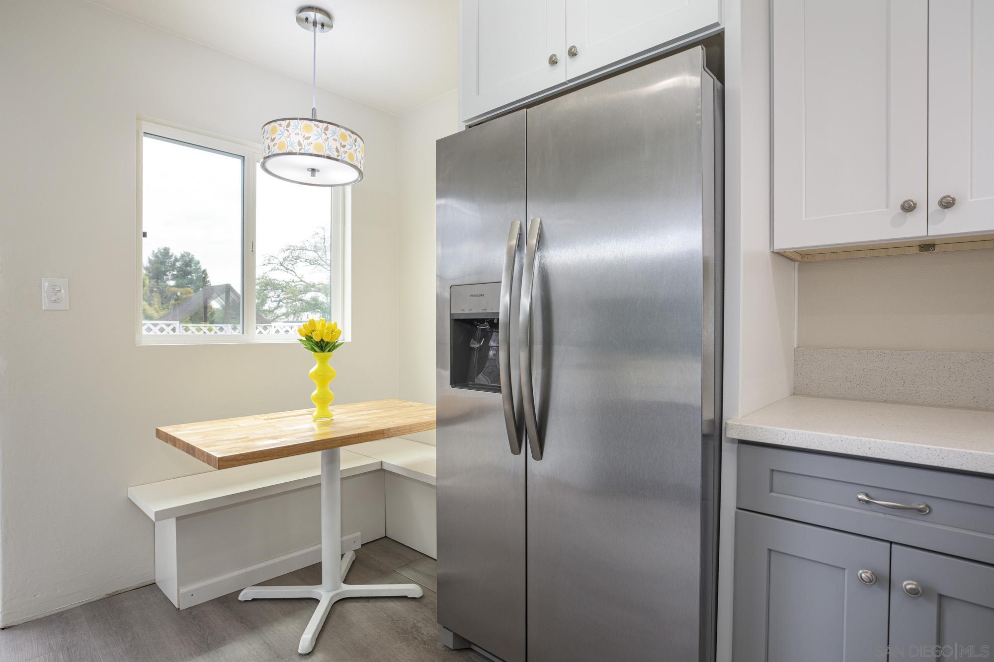 6979 Tower Street La Mesa, CA 91942 - Photo 9 of 30 a kitchen with a refrigerator and a table