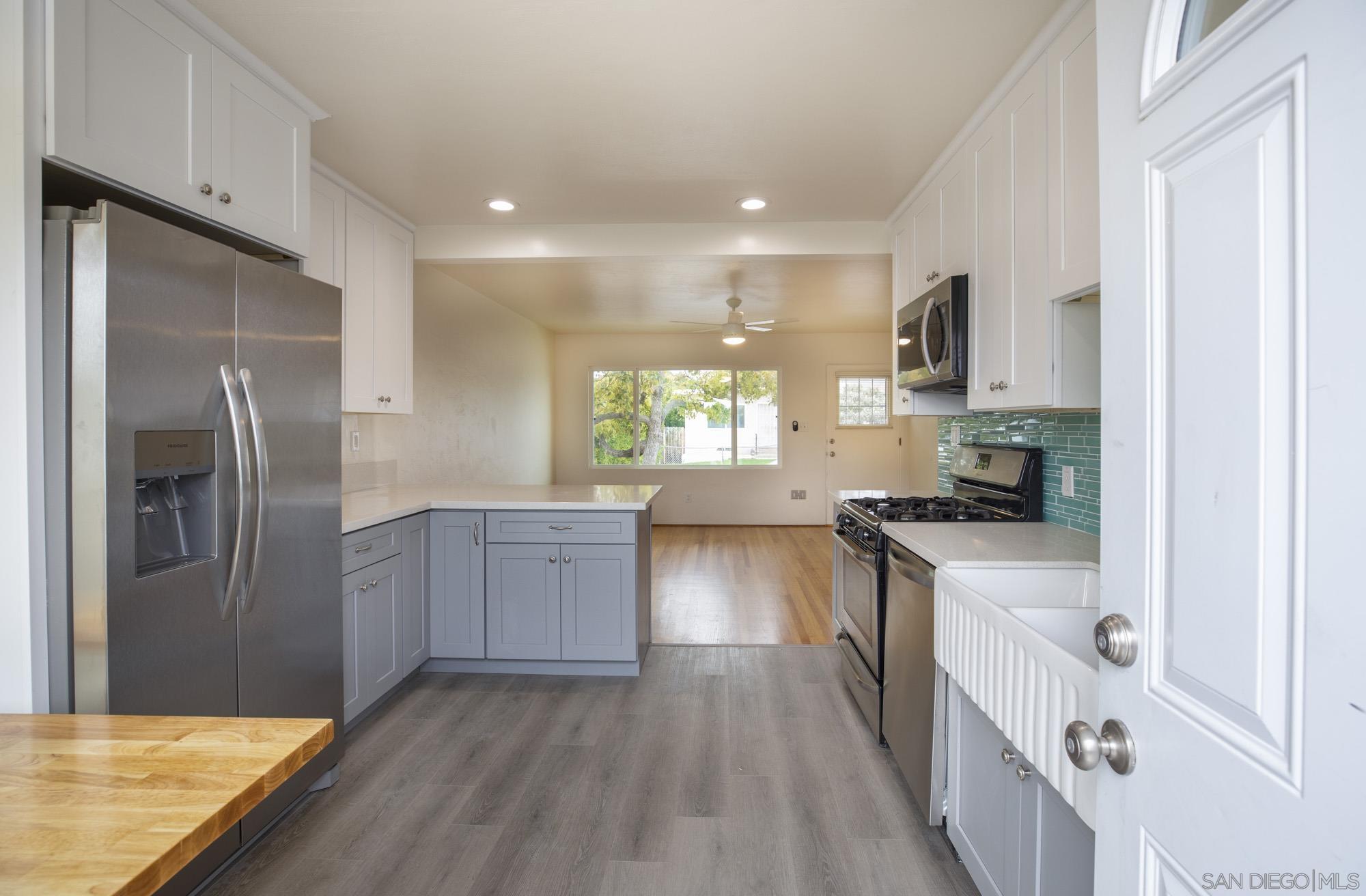 6979 Tower Street La Mesa, CA 91942 - Photo 10 of 30 a kitchen with granite countertop a refrigerator stove top oven and sink