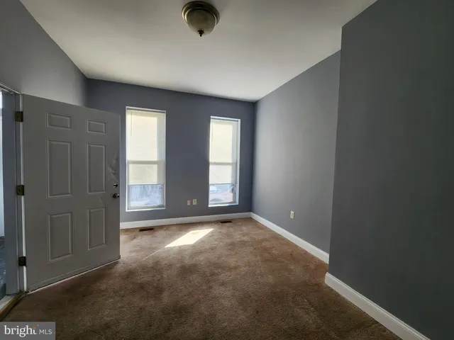 an empty room with windows and closet