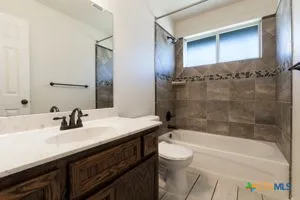 a bathroom with a granite countertop sink a toilet and bathtub