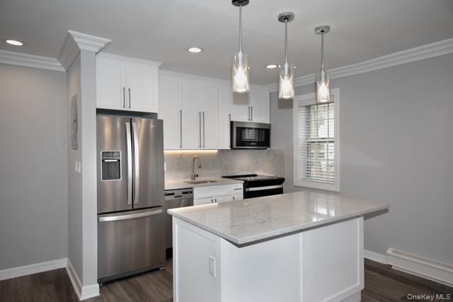 20 Spinning Wheel Road, Unit 2B Massapequa, NY 11758 - Photo 2 of 8 a kitchen with stainless steel appliances a refrigerator a sink a stove a microwave and wooden floor