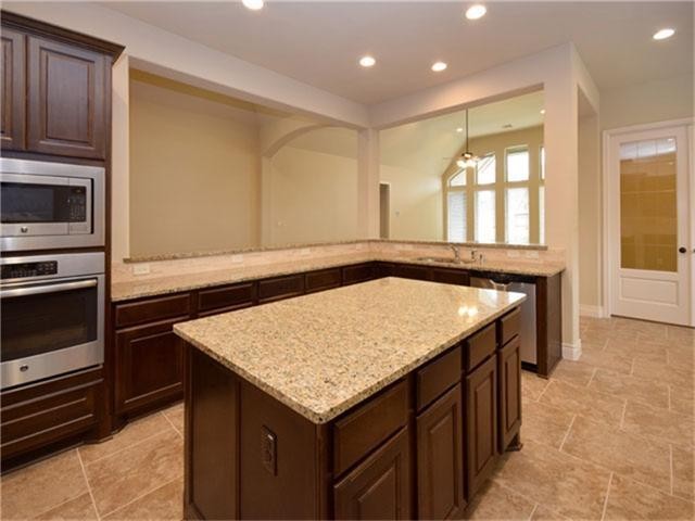 1715 Ketelby Reach Spring, TX 77386 - Photo 6 of 26 a kitchen with a sink a microwave a stove and cabinets