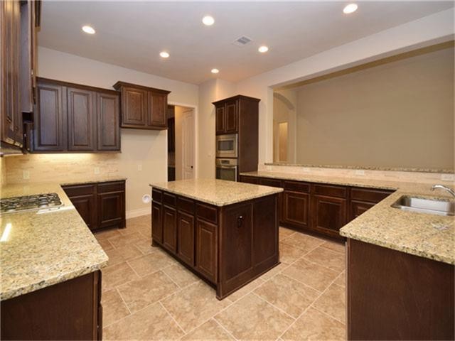 1715 Ketelby Reach Spring, TX 77386 - Photo 7 of 26 a kitchen with stainless steel appliances granite countertop a stove a sink and a refrigerator