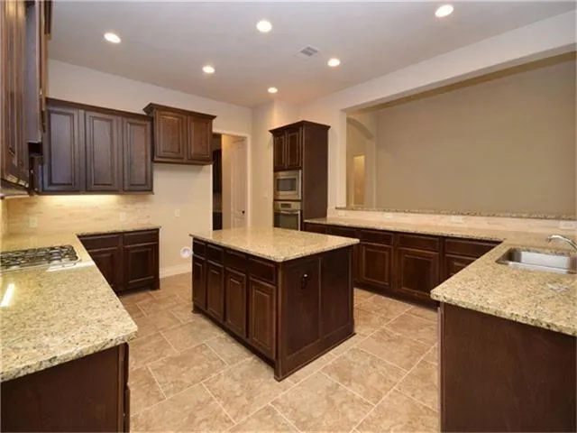 a kitchen with a sink a microwave a stove and cabinets