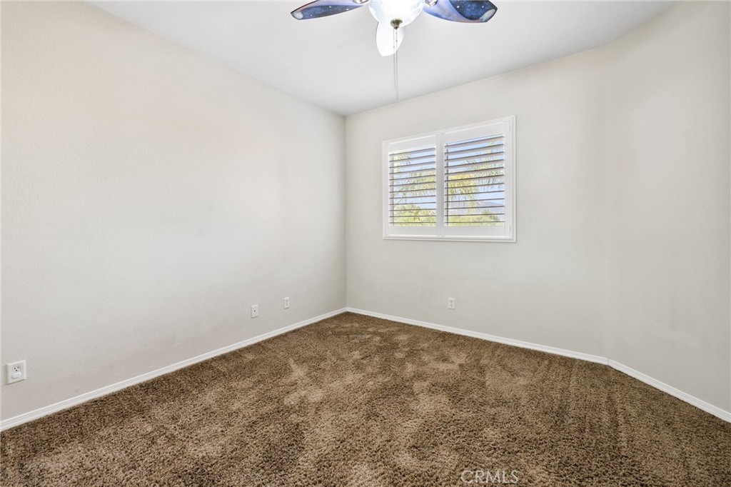 46221 Jane Place Temecula, CA 92592 - Photo 26 of 41 an empty room with a chandelier fan and windows