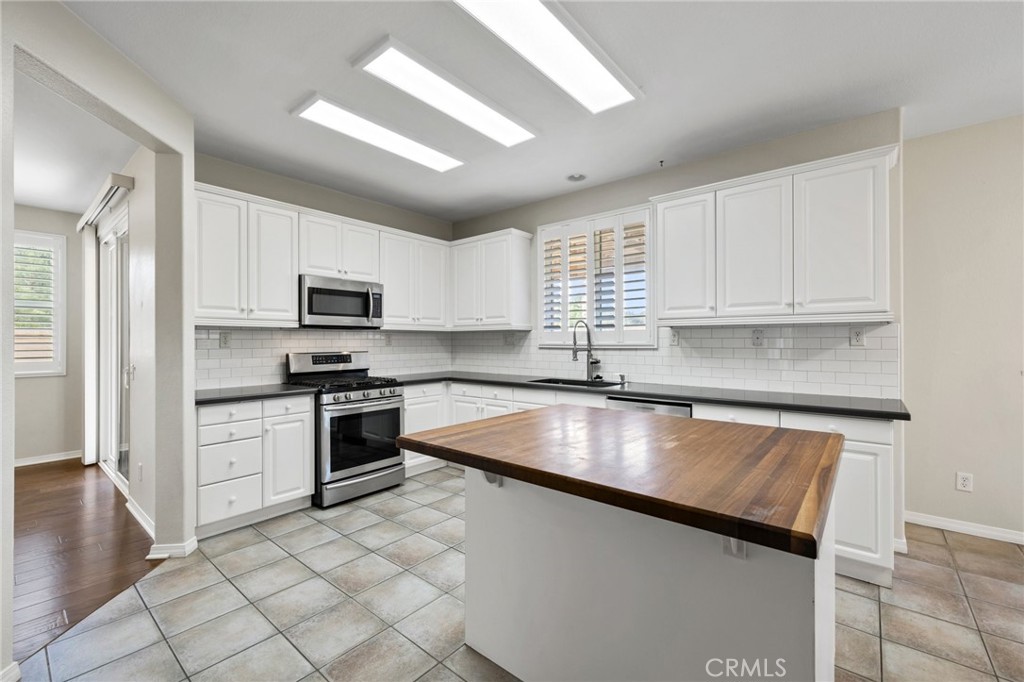 46221 Jane Place Temecula, CA 92592 - Photo 9 of 41 a kitchen with kitchen island granite countertop a stove sink and microwave