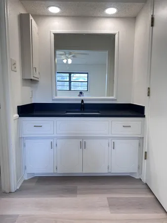 a view of a kitchen with white cabinets