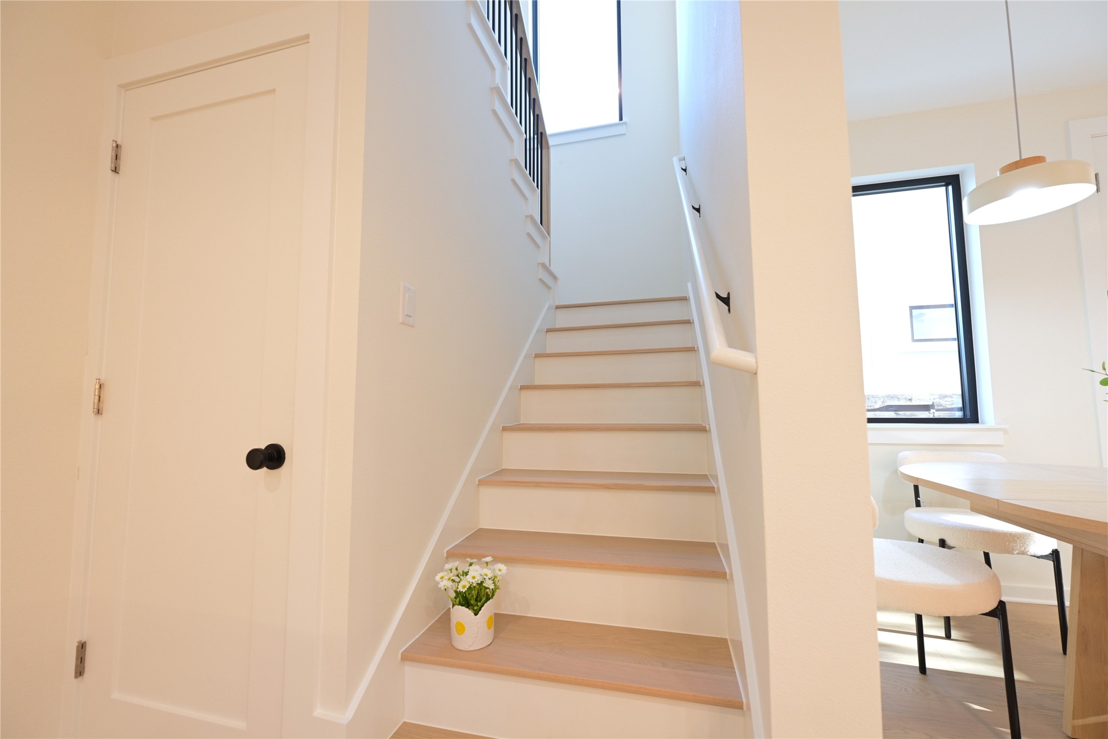 4410 Glomar Avenue, Unit 2 Austin, TX 78721 - Photo 13 of 24 The property features a staircase with light wood treads and white risers, a white handrail, and a black metal baluster
