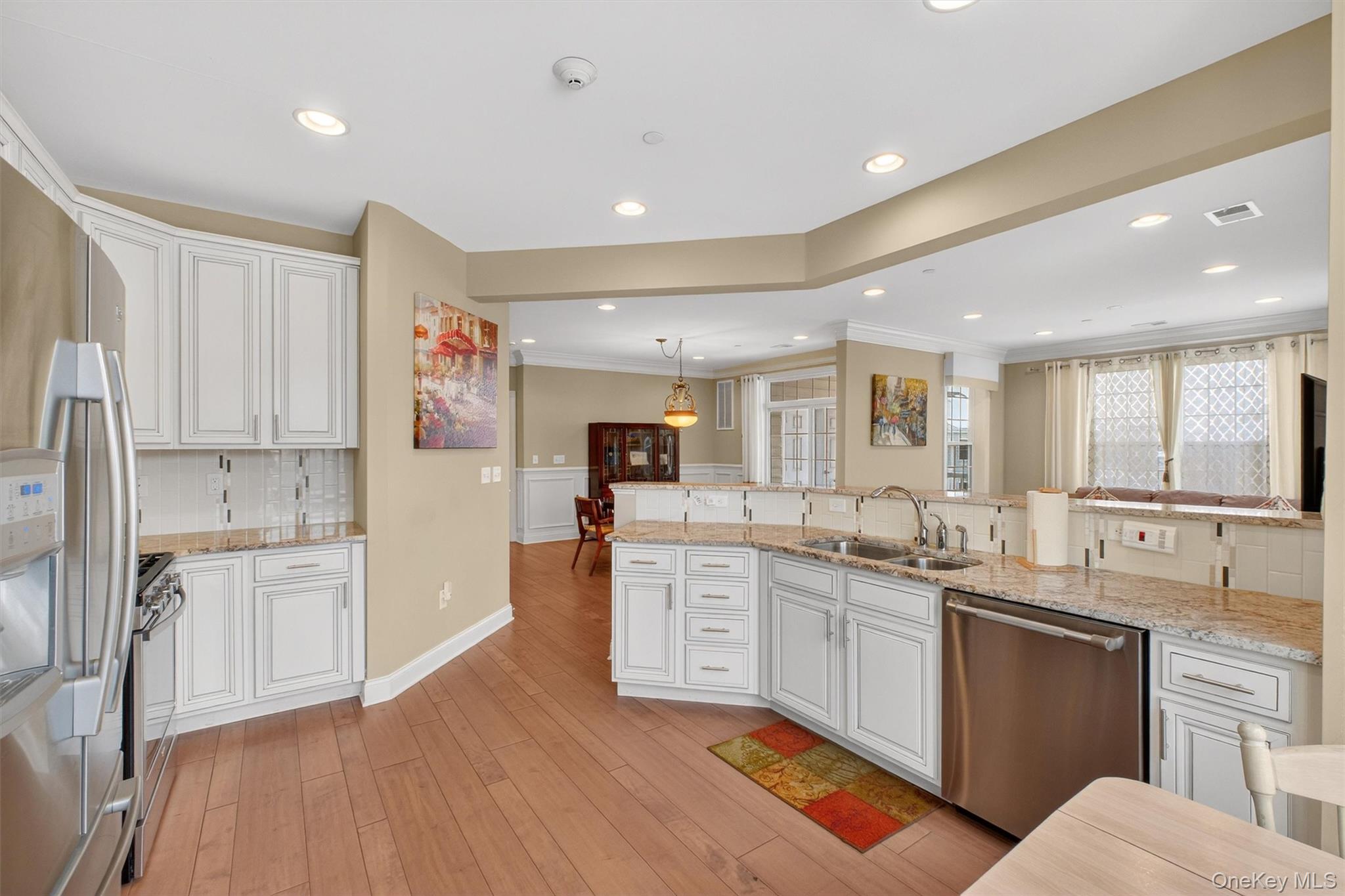 734 Regency Drive Fishkill, NY 12524 - Photo 12 of 45 a large white kitchen with stainless steel appliances granite countertop a stove a sink a refrigerator and white cabinets with wooden floor