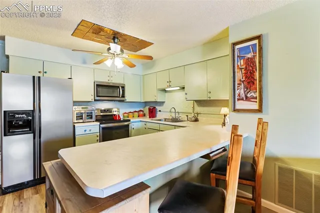 a kitchen with a table chairs refrigerator and microwave