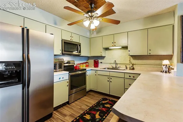 a kitchen with granite countertop a sink stainless steel appliances and cabinets