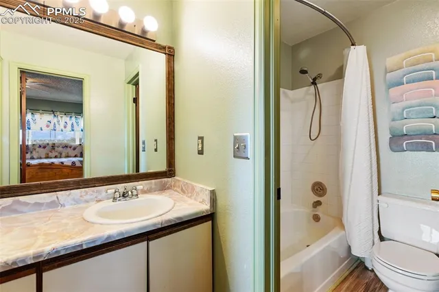 a bathroom with a granite countertop sink toilet and shower