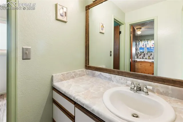 a bathroom with a granite countertop sink and a mirror