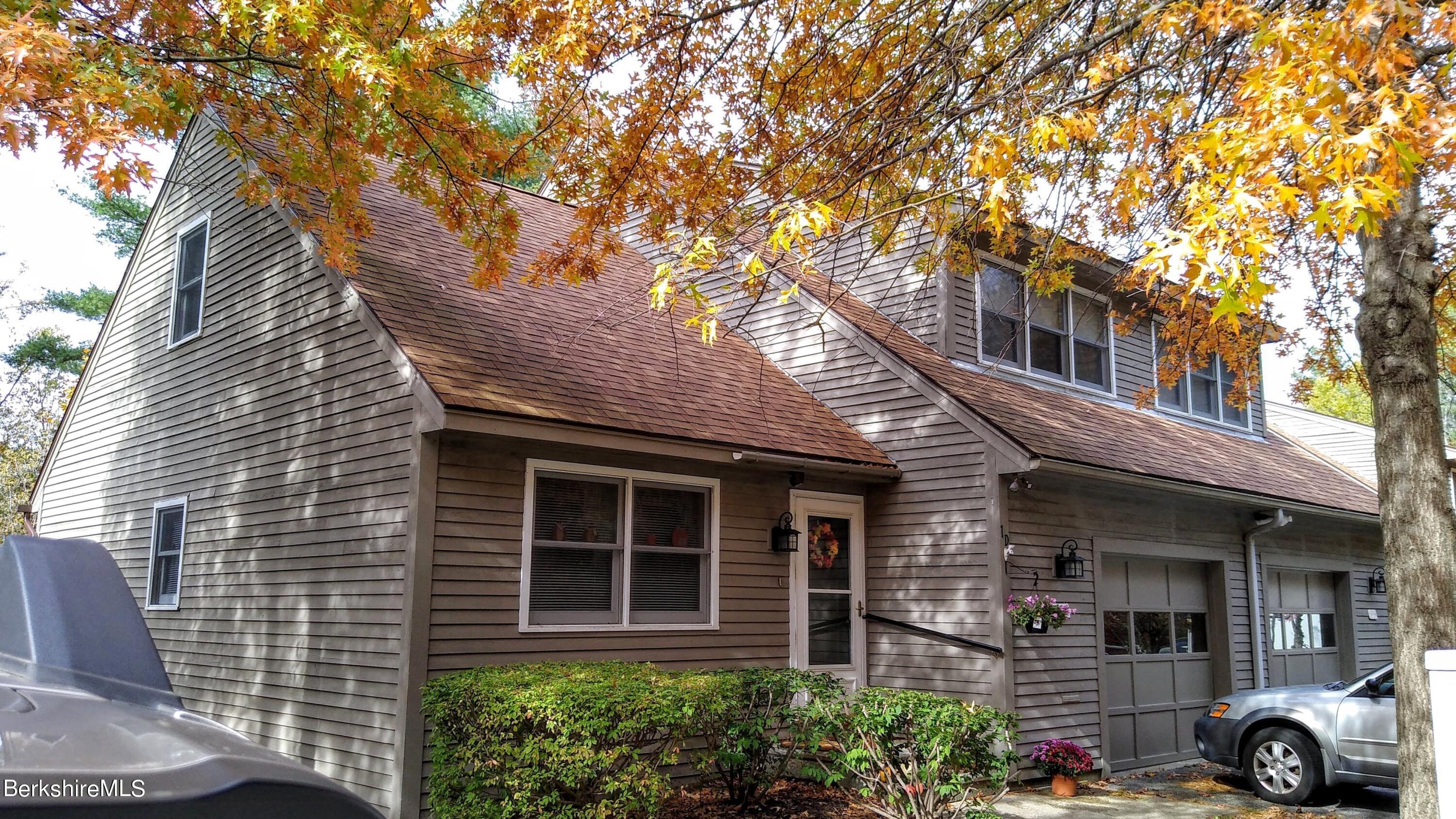 a view of a house with a yard and a large tree