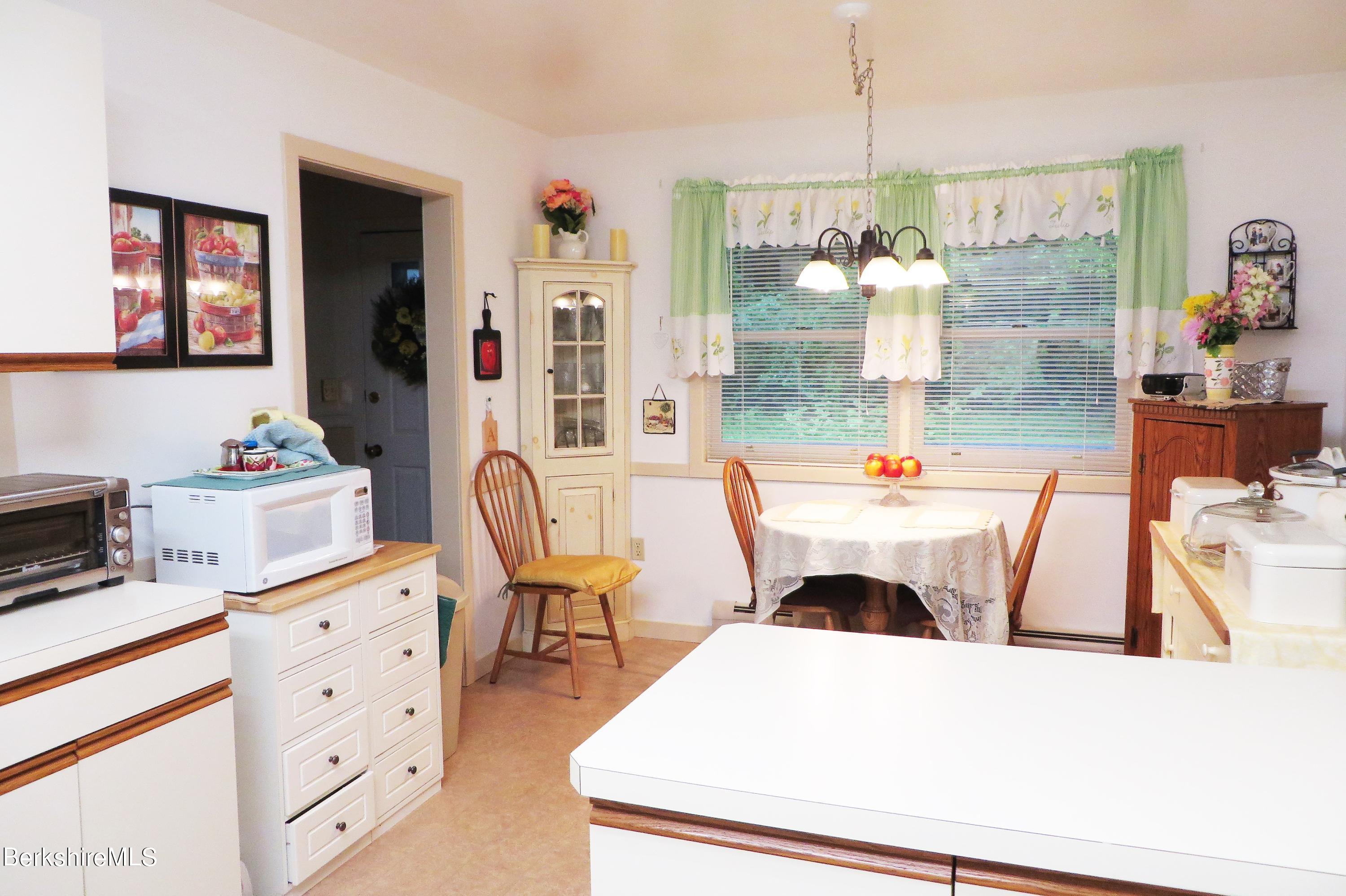751 Mohawk Trail, Unit 1D North Adams, MA 01247 - Photo 6 of 32 a living room with furniture a chandelier and a fireplace