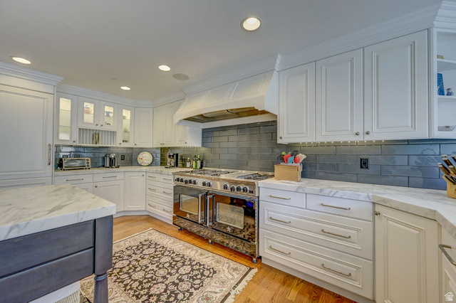 9699 Bypass Road, Unit 5 Alta, UT 84092 - Photo 25 of 54 Gourmet kitchen featuring a professional-grade stainless steel range with double ovens, a custom range hood, and a dark tile backsplash