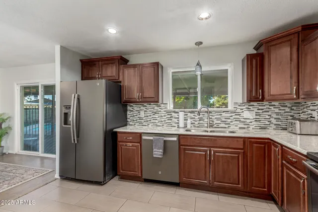 a kitchen with stainless steel appliances granite countertop a refrigerator and a sink