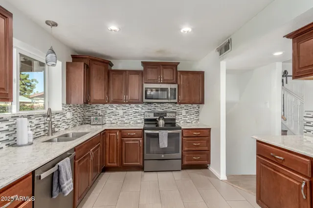 a kitchen with stainless steel appliances granite countertop a sink stove and refrigerator