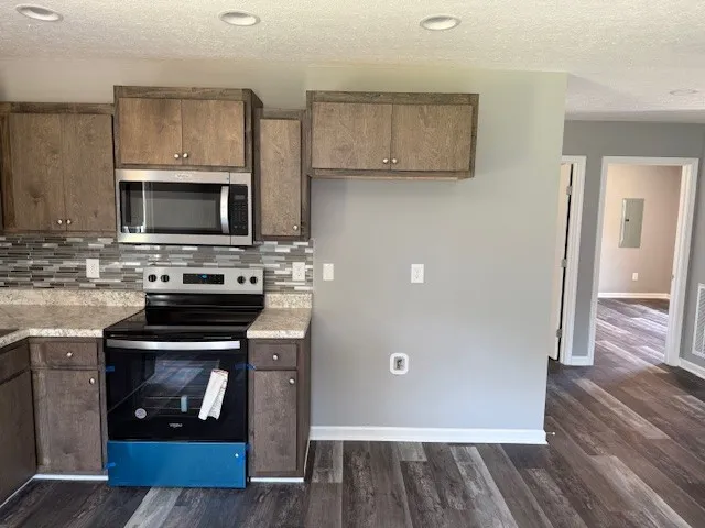 a kitchen with wooden floor and a stove top oven